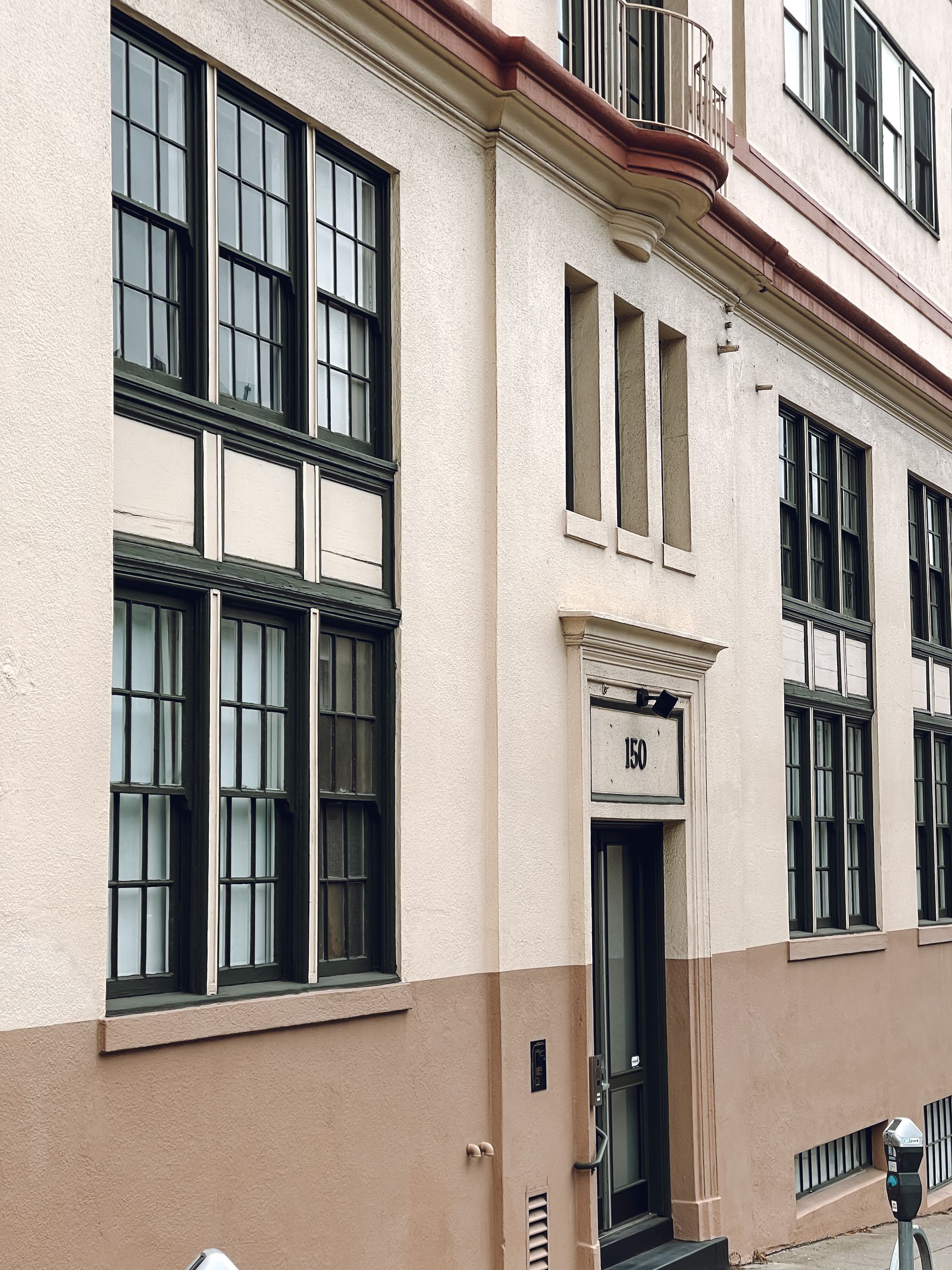 Light-colored masonry office facade with tall windows